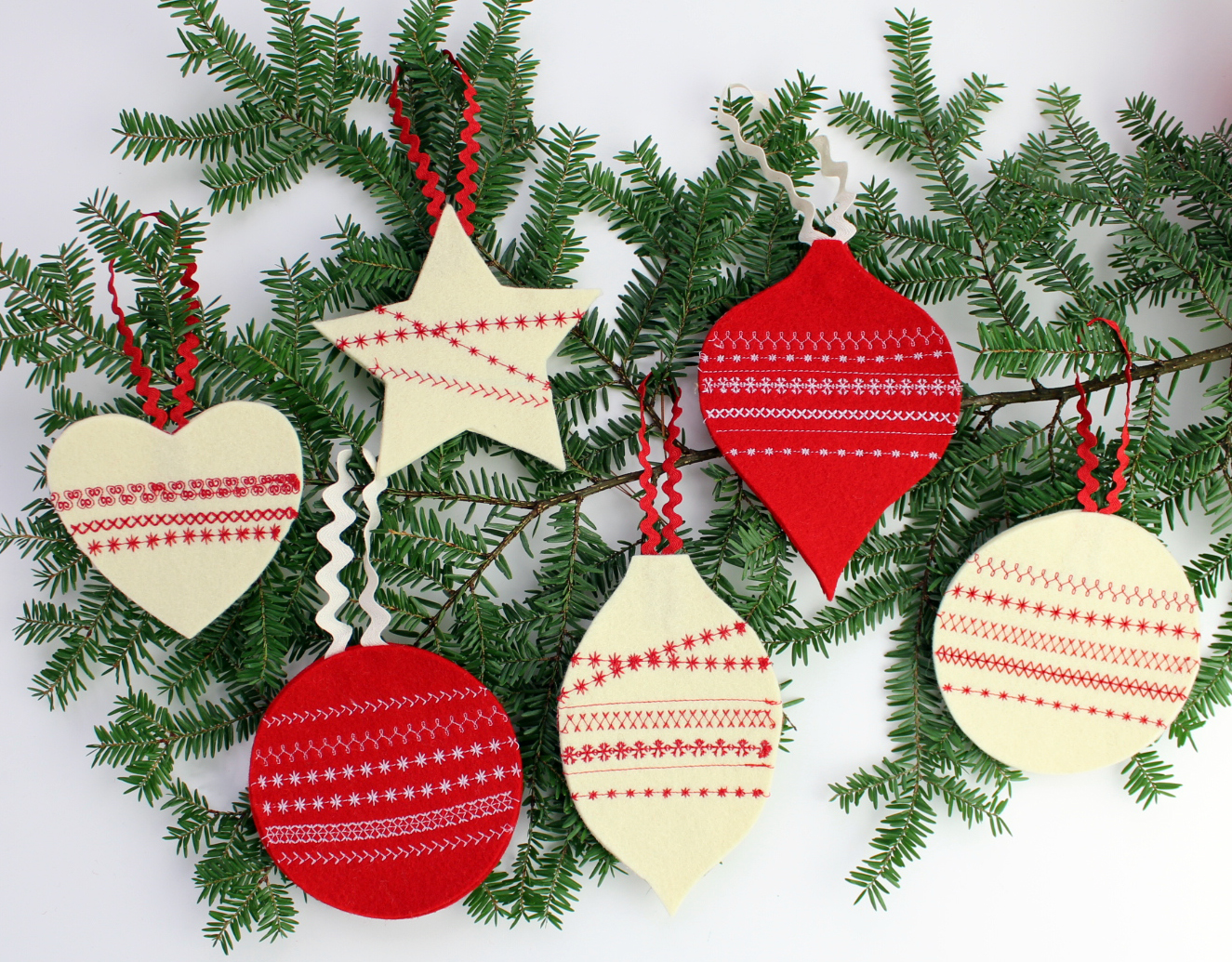 Finished felt ornaments hanging on tree branch.